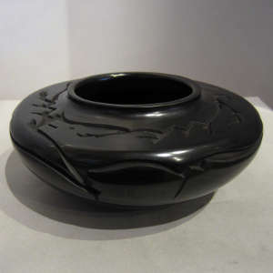 Geometric designs carved into a polished flat-topped black jar