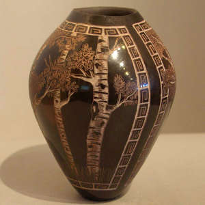 Sgraffito forest and geometric design on a brown jar