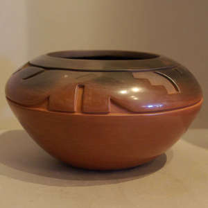 A geometric design carved into a burnished brown jar