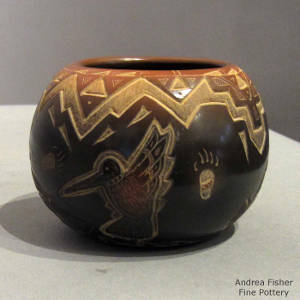 Sgraffito bear paw, cloud pattern, hummingbird and geometric designs decorate a black jar with a sienna rim and sienna spots