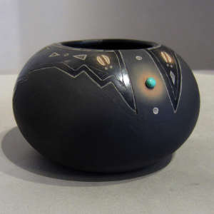 Sgraffito geometric designs and inlaid turquoise on a black jar