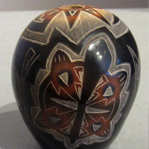 Sgraffito bear paws, deer tracks, turtle and geometric design on a polished black seedpot with sienna spots