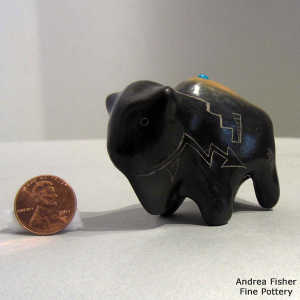 Inlaid stone and sgraffito geometric design on a two tone bison figure