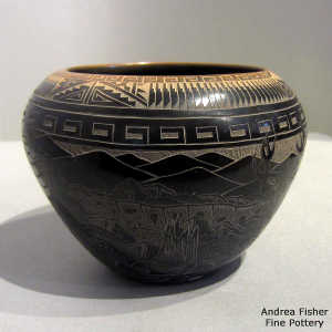 Sgraffito nature, feather and geometric design on a black jar with a sienna rim