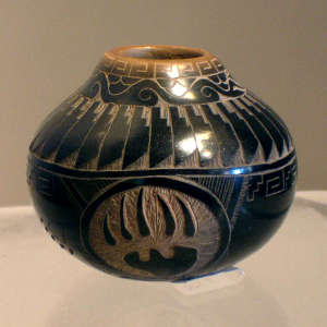 Sgraffito bear paw, avanyu, feather and geometric design on a black jar with a sienna rim
