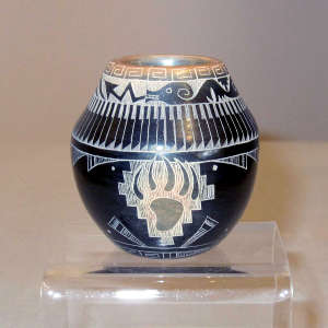 Sgraffito avanyu, feather and geometric design on a miniature black jar with a sienna rim