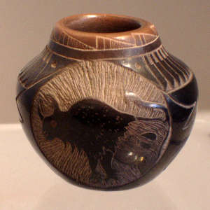 Sgraffito bison, feather and geometric design on a miniature black jar with a sienna rim