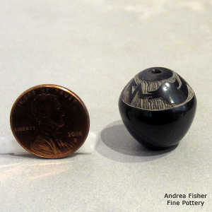 Sgraffito avanyu design on a miniature black jar