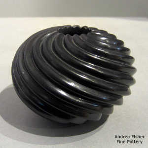 Swirl design carved into a black seed pot