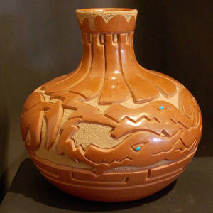 Double avanyu design carved into a red vase