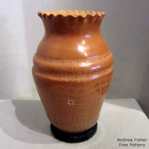 Sgraffito geometric design on a red jar with a pie crust rim