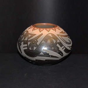 Sgraffito avanyu, feathers and geometric design decorate a black jar with sienna spots and rim