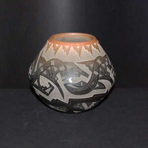 Sgraffito avanyu, bear paws and geometric design on a black jar with sienna spots and a sienna rim
