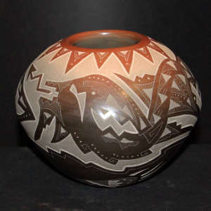 Sgraffito bear paw, avanyu and geometric design on a black jar with a sienna rim
