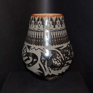 Sgraffito avanyu, feather, bear paw and geometric design on a black jar with a sienna rim