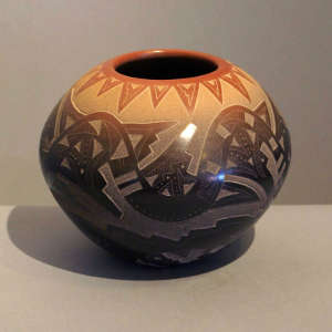 Sgraffito avanyu, bear paw and geometric design on a black jar with a sienna rim