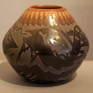 Sgraffito avanyu, bear paw and geometric design on a black jar with a sienna rim