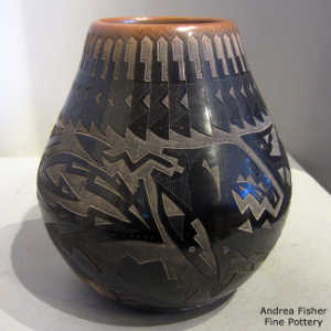 Sgraffito bear paws, avanyu and geometric design on a black jar with a sienna rim and sienna spots