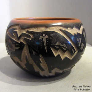 Sgraffito bear paw, avanyu and geometric design on a black jar with a sienna rim