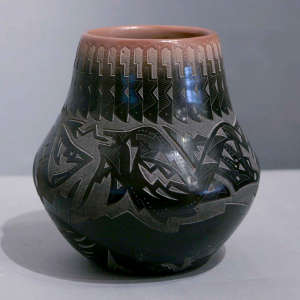 Sgraffito avanyu and geometric design on a black jar with a sienna rim