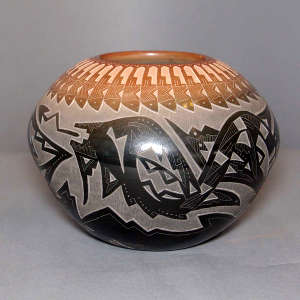 Sgraffito bear paw, feather, avanyu and geometric design on a black jar with a sienna rim