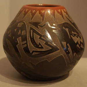 Sgraffito avanyu, bear paws and geometric designs with sienna spots and sienna rim on a black pot