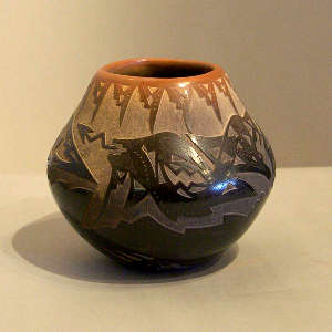 Sgraffito bear paw, avanyu and geometric design on a black jar with a sienna rim