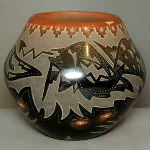 Sgraffito avanyu, bear paw and geometric design on a black jar with a sienna rim
