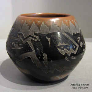 Sgraffito avanyu, bear paws and geometric design on a black jar with a sienna rim and spots