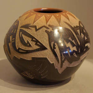 Sgraffito avanyu and bear claw design on a black jar with sienna rim and sienna spots