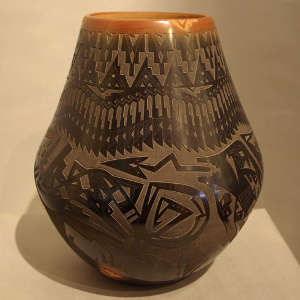 Sgraffito avanyu, feathers, bear paws and geometric design on a black jar with sienna rim and spots