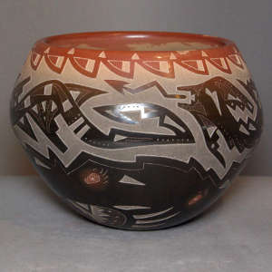 Sgraffito avanyu, bear paw and geometric design on a black pot with sienna riom and spots