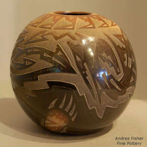 Sgraffito avanyu, bear claw and geometric design on a black jar with sienna rim and sienna spots