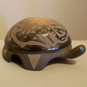Inlaid stones, sienna spot and sgraffito avanyu, bear paws and geometric design on a black and black turtle