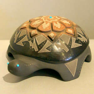 Carved and sgraffito geometric design on a black turtle with a sienna spot and inlaid stone