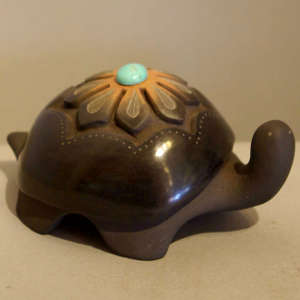 Black turtle carved with geometric design plus a sienna spot and an inlaid stone