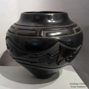 Avanyu and geometric design carved into a black jar