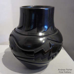 Avanyu and geometric design carved into a polished black jar
