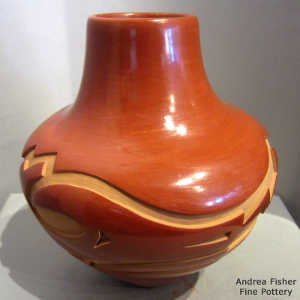 Avanyu design carved into a red jar