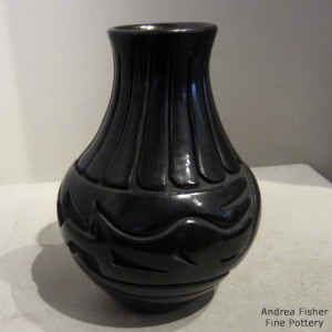 An avanyu design carved into a black jar
