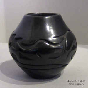 An avanyu design carved into a black jar