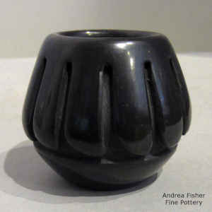 A geometric design carved into a miniature black jar