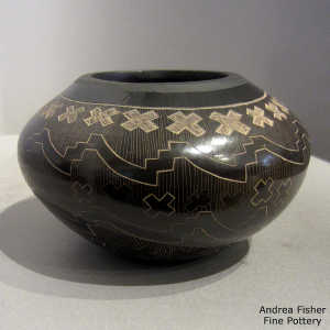 Sgraffito geometric design on a black jar
