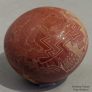 Sgraffito bear, hunter and geometric design on a red seed pot