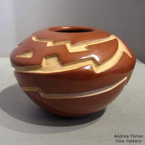 Avanyu design carved into a red jar