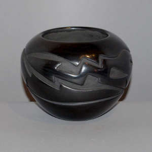 Avanyu design carved into a gunmetal black jar