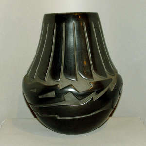 Feather and avanyu design carved into a large black jar