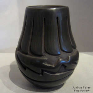 Avanyu and feather design carved into a black jar