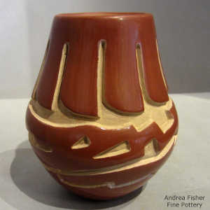 Avanyu and feather design carved into a red jar