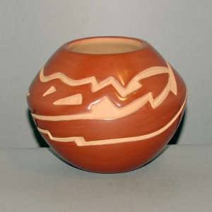 Avanyu design carved into a polished red jar